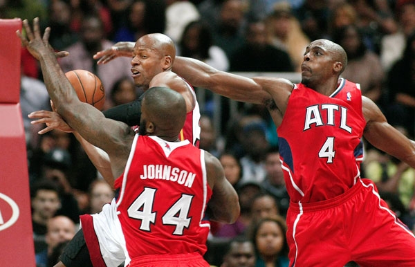 Miami Heat guard Allen goes against the defense of Atlanta Hawks forwards Johnson and Tolliver during their NBA basketball game in Atlanta, Georgia
