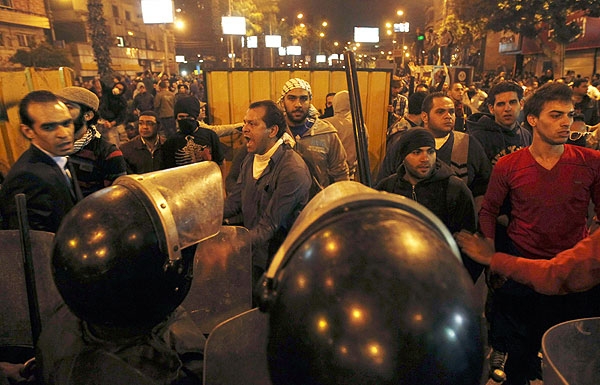 Anti-Mursi protesters scuffle with riot police during clashes with supporters of Egyptian President Mohammed Mursi, near the presidential palace in Cairo, December 5, 2012