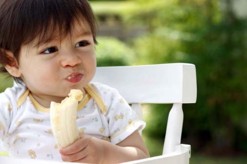 کودک در حال خوردن موز