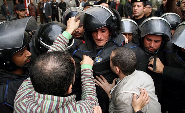 Egyptian demonstrators harass a soldier during a protest in front of the Tunisian embassy in Cairo, Egypt