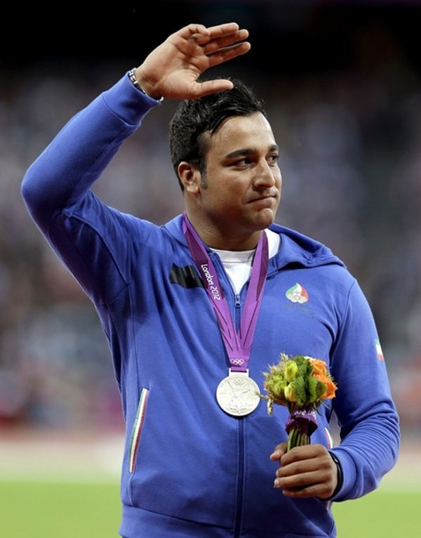 Iran's Ehsan Hadadi waves after receiving a silver medal for the men's discus during the athletics in the Olympic Stadium at the 2012 Summer Olympics, London, Wednesday, Aug. 8, 2012.