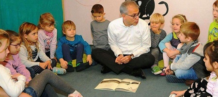 وزیر آلمانی در حال خواندن کتاب نویسنده ایرانی برای بچه‌های سرزمینش