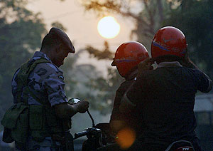 یکی از نیرو‌های امنیتی سریلانکا در حال بازرسی مدارک موتور سواران در نزدیکی پایگاه هوایی کلمبو