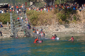 People struggle over the collapsed suspension bridge over Bheri river in West Nepal -REUETERS