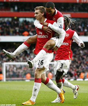 Nicklas Bendtner gives Theo Walcott a lift after his strike against Villa but there was no sign of Emmanuel Adebayor