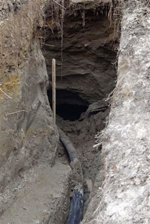 A pipe runs into a hole that leads to the underground hideout of a doomsday cult outside the settlement of Nikolskoye in the Penza region 