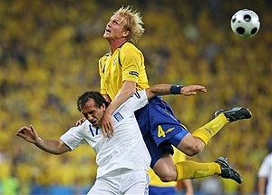 Greece's Fanis Gekas, and Sweden's Petter Hansson challenge for the ball 