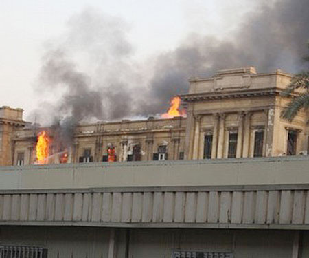 Egyptian parliament building while smoke rises from the burning building in Cairo, Egypt,
