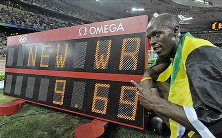 Jamaica's Usain Bolt poses next to the scoreboard after setting a new world record as he wins the gold medal in the men's 100-meter final during the athletics competitions in the National Stadium at the Beijing 2008 Olympics in Beijing, Saturday, Aug. 16, 2008. 