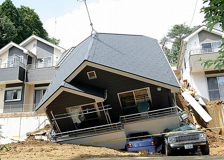 A house leans perilously after being damaged by heavy rain in Hachioji city, western suburb of Tokyo on August 29, 2008.