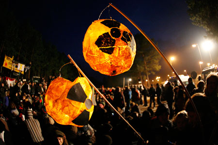 Protesters carry lanterns with anti-nuclear symbols during a demonstration in front of the interim storage facility for nuclear waste near Gorleben