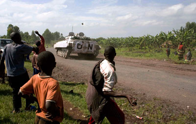 People throw stones at UN peacekeepers patrolling on a road in Kibati 