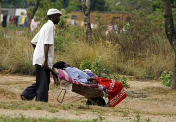 یک مرد زیمبابوه‌ای یکی از بستگان مبتلا به وبایش را باگاری دستی به بیمارسان می‌برد