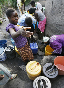 زنان زیمبابوه‌ای که آب  مصرفی روزانه خود را از چاهی سرباز جمع می‌کنند