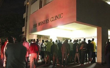 People wait outside at the Avenues Clinic in Harare, Friday, March 6, 2009, where Morgan Tsvangirai, Zimbabwe's Prime Minster is receiving treatment following a car crash