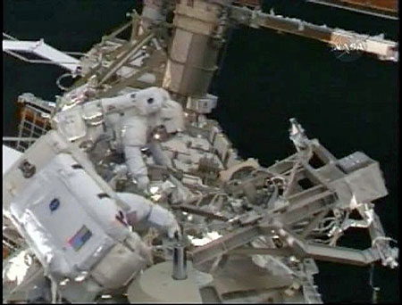 Space shuttle Discovery astronauts Joseph Acaba (foreground) and Richard Arnold work outside the International Space Station in this image from NASA TV March 23, 2009. 
