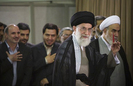 Iran's Supreme Leader Ayatollah Ali Khamenei leaves the polling station with an identification card in hand after casting his ballot in the Iranian presidential election in Tehran June 12, 2009.