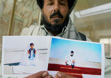 An Afghan man Gul Nak, the uncle of Guantanamo Bay prisoner Mohammad Jawad poses with pictures of Jawad in Kabulin