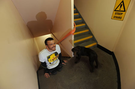Kurt Fearnley, with his dog Alby, after crawling up the 1,504 fire stairs in Sydney Tower. (AAP: Dean Lewins)