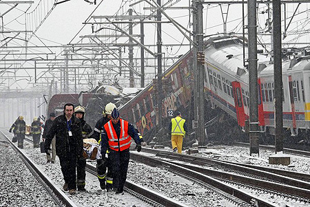Emergency workers carry the victim of a train crash on a stretcher at the site of the crash near Halle February 15, 2010. Two trains crashed head-on outside Brussels on Monday, killing at least 20 people, officials and Belgian broadcaster VRT said