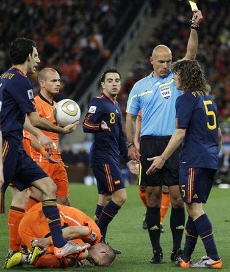 1.	Referee Howard Webb of England, second from right, shows a yellow card to Spain's Carles Puyol, right, for a foul on Netherlands' Arjen Robben, bottom left, during the World Cup final soccer match between the Netherlands and Spain at Soccer City in Johannesburg, South Africa, Sunday, July 11, 2010.