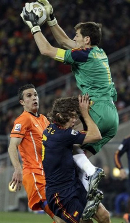 3.	Spain goalkeeper Iker Casillas, right, makes a save above Netherlands' Robin van Persie, left, and Spain's Carles Puyol during the World Cup final soccer match between the Netherlands and Spain at Soccer City in Johannesburg, South Africa, Sunday, July 11, 2010.