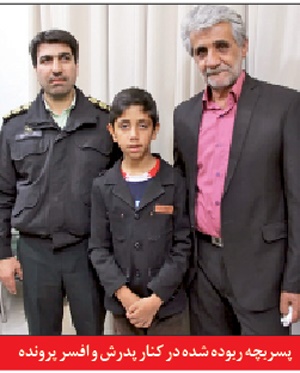 پسربچه ربوده شده در کنار پدرش و افسر پرونده